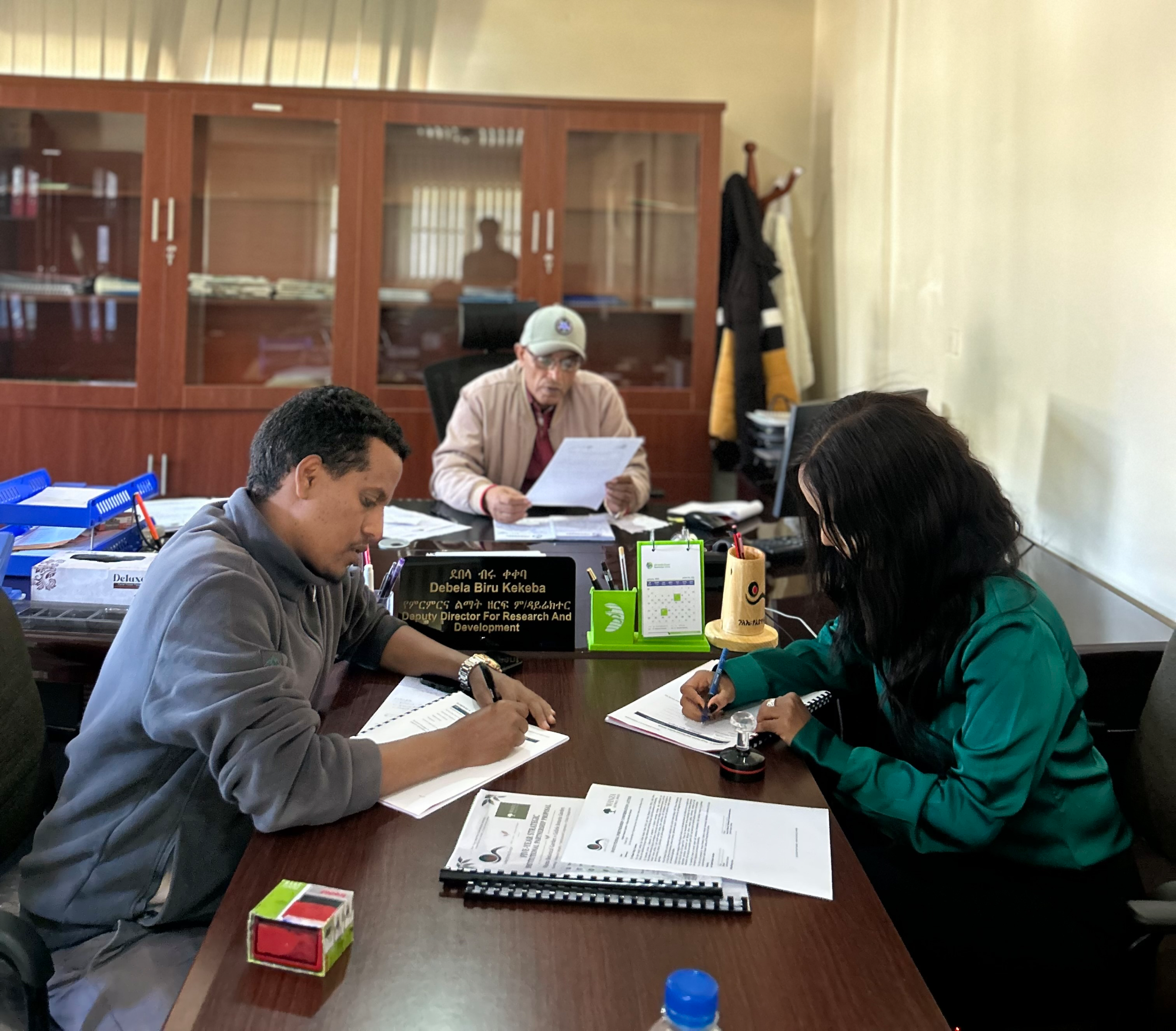 Tripartite meeting inside the Deputy Director's office.