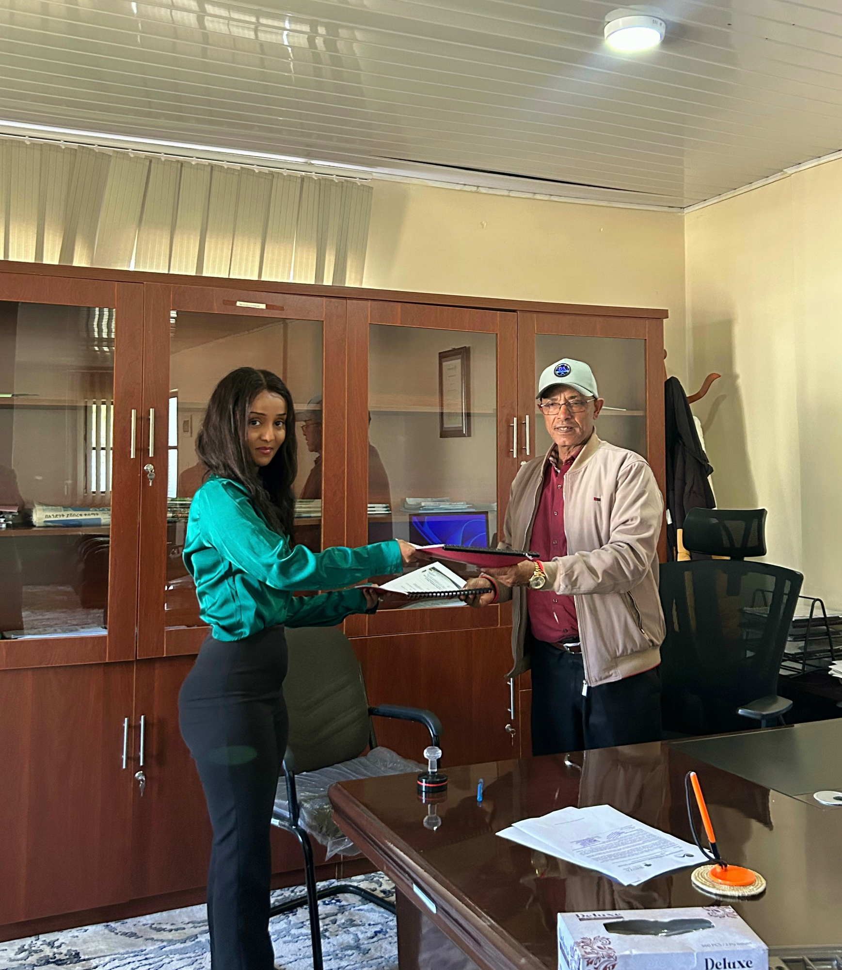 Wanza Botanical Garden’s Managing Director and Gullele Botanic Garden’s Deputy Director, Debela Biru Kekeba, shake hands while exchanging documents at the partnership signing ceremony.
